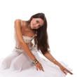 woman arabic belly dancer in white costume sitting on the floor
