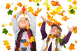 Foto: girls playing with autmn leaves on white girls playing with autmn leaves on white