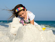 Child Building Sandcastle on a Beach