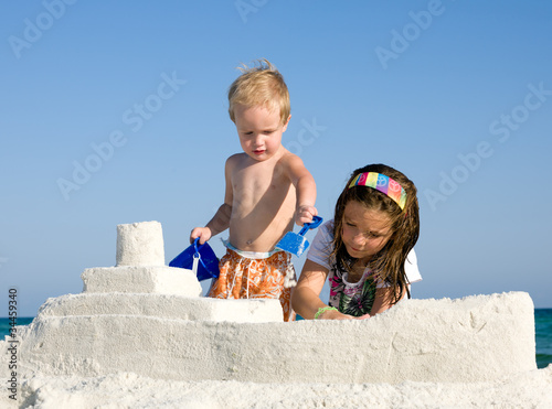 Photo: Kids Building Sandcastle on a Beach Kids Building Sandcastle on a Beach