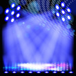 Blue spotlight background with light show effects.