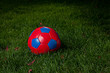 Red and blue soccer ball in a field Red and blue soccer ball in a field