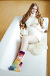 Beautiful young pregnant woman sitting on sofa