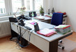 Schreibtisch im Büro mit Akten und moderner Bürotechnik Schreibtisch im Büro mit Akten und moderner Bürotechnik