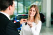 Foto: Woman buying car - key being given Woman buying car - key being given