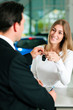 Woman buying car - key being given