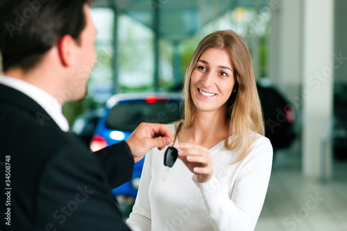 Foto: Woman buying car - key being given Woman buying car - key being given