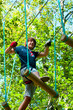 Jeune homme en train de faire un acrobranche 2 Jeune homme en train de faire un acrobranche 2
