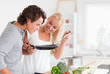 Foto: Couple cooking with a pan Couple cooking with a pan