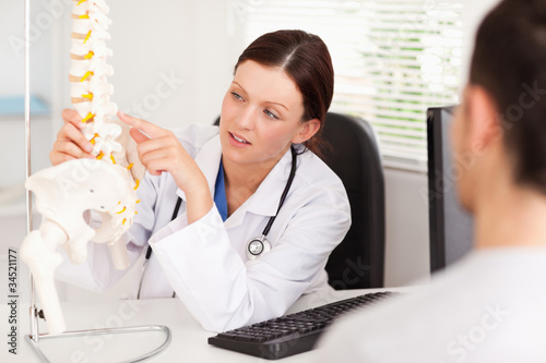 Photo: Female doctor pointing on a bone Female doctor pointing on a bone