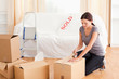 Foto: Female preparing cardboards for transport Female preparing cardboards for transport
