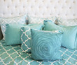 Teal colored cushions on bed