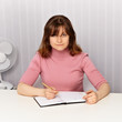 Young woman sits at white table