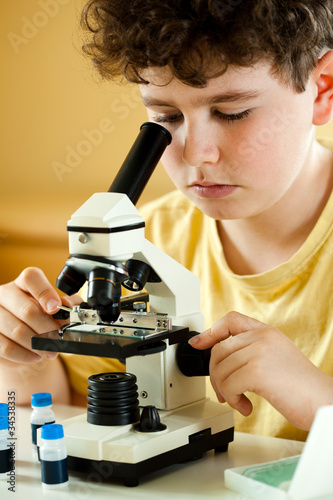 Photo: Boy examining preparation under the microscope Boy examining preparation under the microscope