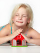 Foto: Cute little girl is playing and dreaming of a new house Cute little girl is playing and dreaming of a new house