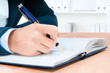 Photo: Cropped image of hand of young woman taking notes Cropped image of hand of young woman taking notes