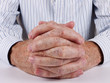 Man at desk, hands clasped