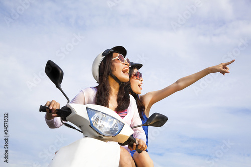 Photo: happy girls riding scooter enjoy summer vacation happy girls riding scooter enjoy summer vacation