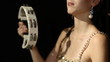 lovely young woman percussionist playing the tamborine