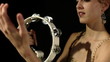 lovely young woman percussionist playing the tamborine