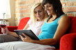 Happy female friends with tablet computer