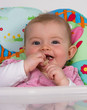 Baby girl eating finger food