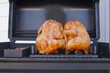 Two whole barbequed chickens on the grill