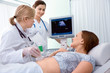 Pregnant woman getting ultrasound diagnostic from doctor