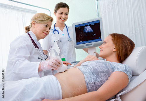 Photo: Pregnant woman getting ultrasound diagnostic from doctor Pregnant woman getting ultrasound diagnostic from doctor