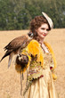 The woman in a beautiful old style dress with falcon has a rest The woman in a beautiful old style dress with falcon has a rest
