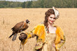 The woman in a beautiful old style dress with falcon has a rest The woman in a beautiful old style dress with falcon has a rest