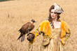 The woman in a beautiful old style dress with falcon has a rest The woman in a beautiful old style dress with falcon has a rest