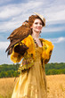 The woman in a beautiful old style dress with falcon has a rest The woman in a beautiful old style dress with falcon has a rest