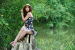 Photo: portrait of young woman sitting on stump portrait of young woman sitting on stump