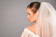 profile portrait of attractive young bride under veil in studio