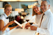 Smiling bartender with customers at the bar