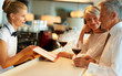 Female barmaid taking order from senior couple