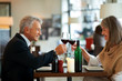 Senior couple celebrating by toasting wine glasses