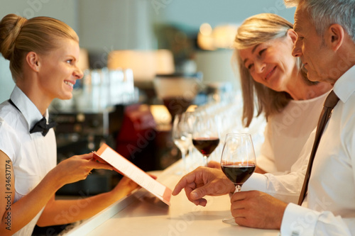 Foto: Mature couple ordering wine at the bar Mature couple ordering wine at the bar