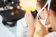 Closeup of female researcher using microscope