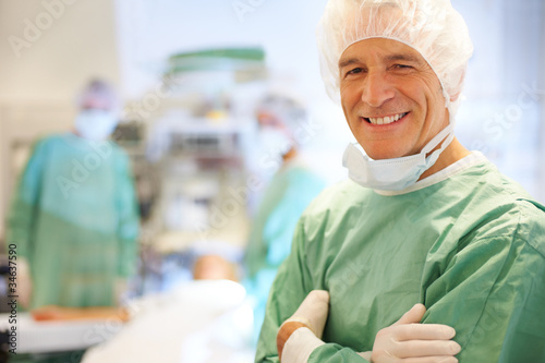 Photo: Portrait of smiling doctor in operating room Portrait of smiling doctor in operating room