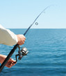 Cropped image of man fishing with baitcasting reel on the beach