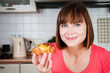 Beautiful woman holds sweet bun with fruits