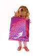 Little girl looking into a pink shopping bag