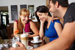 Freunde schauen auf Handy im Café