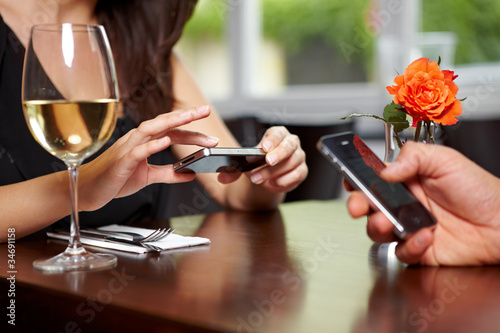 Foto: Hände mit Handys im Restaurant Hände mit Handys im Restaurant