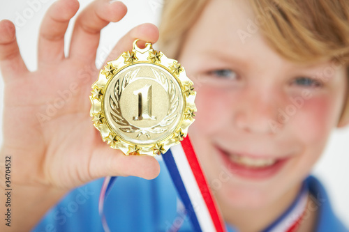 Photo: Young boy showing off medal Young boy showing off medal