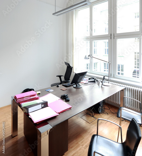 Photo: Aufgeräumter Schreibtisch mit weisser Wand im Büro Aufgeräumter Schreibtisch mit weisser Wand im Büro