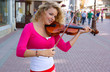 Pretty young woman with violin in the street