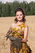 The woman in a beautiful old style dress with falcon The woman in a beautiful old style dress with falcon